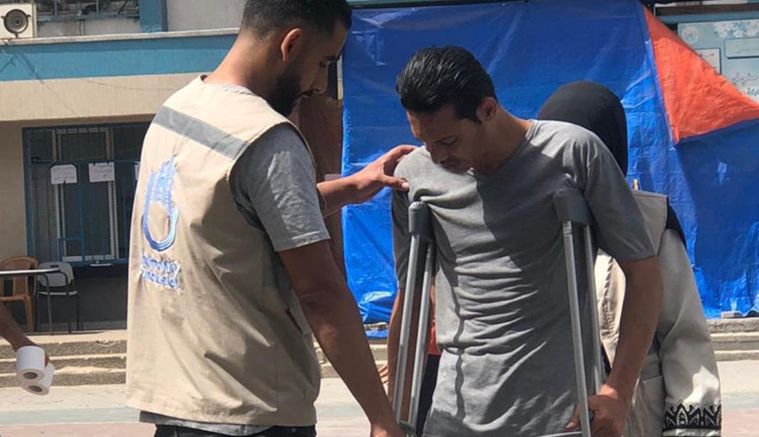 Haitham in a displaced camp, helping a patient