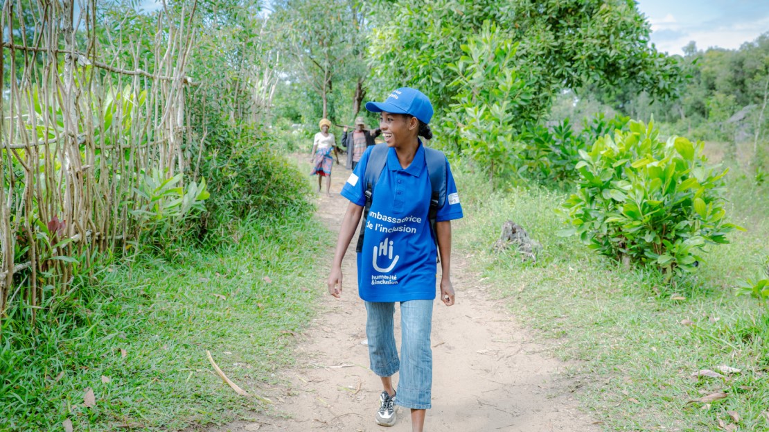 A teenage girl walks along a path to school.
