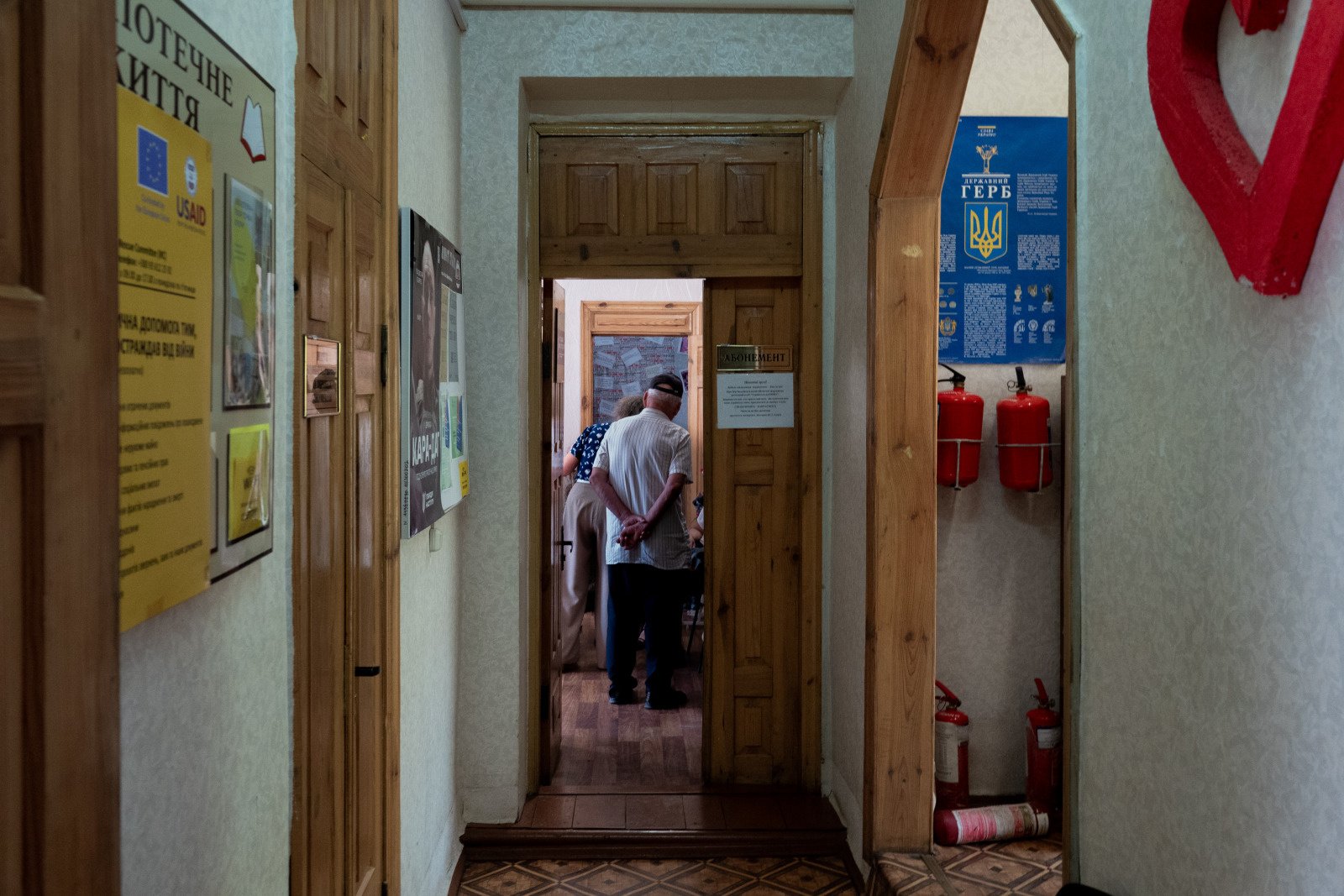 Ukrainians experiencing displacement wait to meet HI protection teams in the children's library in Yurivka, eastern Ukraine. 