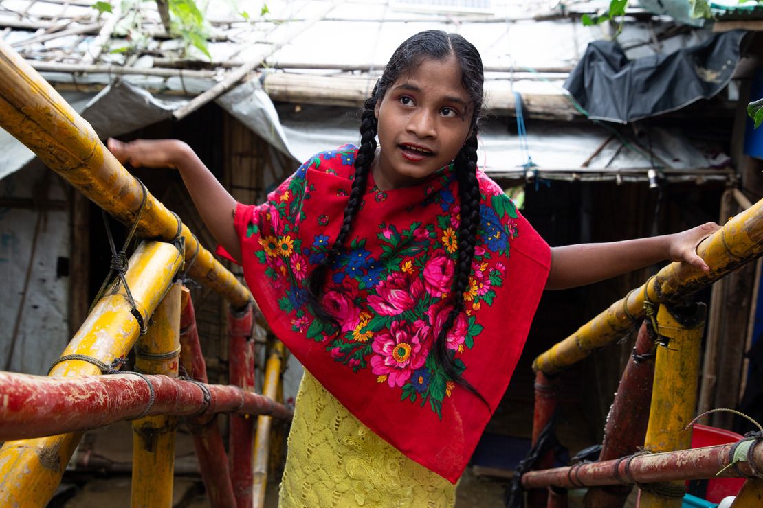 Ajida climbing the stairs leading out of her shelter, helped by ramps supplied and installed by HI, in Ukhiya Camp 21 in Cox's Bazar 